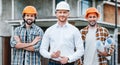 group of successful architects in hard hats looking at camera in front of Royalty Free Stock Photo