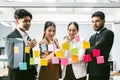 Group of successful Asian businessmen teamwork. Brainstorm meeting with sticky paper notes on the glass wall for new ideas.