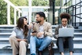 Group of successful young business people, leaders in marketing and motivation, stand in front of office building and consult Royalty Free Stock Photo