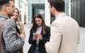 Group of successful young business people, leaders in marketing and motivation, stand in front of office building and consult Royalty Free Stock Photo