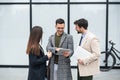 Group of successful young business people, leaders in marketing and motivation, stand in front of office building and consult Royalty Free Stock Photo