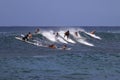 Group of surfers in Hawaii chasing the wave Royalty Free Stock Photo