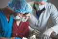 Group of surgeons at work operating in surgical theatre. Resuscitation medicine team wearing protective masks Royalty Free Stock Photo