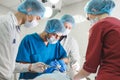 Group of surgeons at work operating in surgical theatre. Resuscitation medicine team wearing protective masks holding Royalty Free Stock Photo