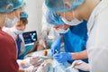 Group of surgeons at work operating in surgical theatre. Resuscitation medicine team wearing protective masks holding Royalty Free Stock Photo