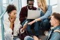 Group of surprised multicultural students with laptop and smartphone Royalty Free Stock Photo