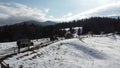 A group of SUVs rides through a snowy meadow of a mountain