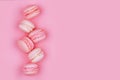 Group of sweet pink and white mini macarons on soft pink paper