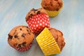 Group of tasty colored muffins placed on wooden blue table Royalty Free Stock Photo