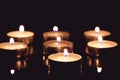 Group of tea candles on a black background. Selective focus Royalty Free Stock Photo