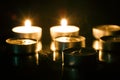 Group of tea candles on a black background. Selective focus Royalty Free Stock Photo