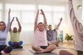 Group With Teacher Sitting On Exercise Mats Stretching In Yoga Class Inside Community Center Royalty Free Stock Photo