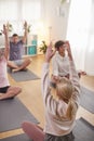 Group With Teacher Sitting On Exercise Mats Stretching In Yoga Class Inside Community Center Royalty Free Stock Photo