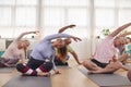 Group With Teacher Sitting On Exercise Mats Stretching In Yoga Class Inside Community Center Royalty Free Stock Photo