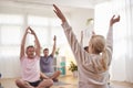 Group With Teacher Sitting On Exercise Mats Stretching In Yoga Class Inside Community Center Royalty Free Stock Photo