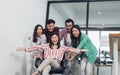 Group of teamwork businesspeople pushing a chair with female leader to move forward to achieve goal and success in modern indoor