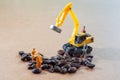 Group of teamwork miniature people, small model human figure and yellow excavator to check coffee beans for made the best coffee