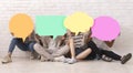 Group of teen friends covering faces with colorful speech bubbles Royalty Free Stock Photo