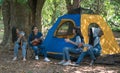 Group of teenage asian girls camping and resting at forest playing ukulele and take a photo happy together. Royalty Free Stock Photo