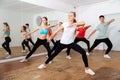 Teenagers exercising with coach in choreography class