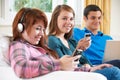 Group Of Teenage Friends Enjoying Technology At Home