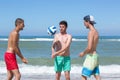 Group teenage friends playing volleyball on beach Royalty Free Stock Photo