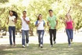 Group Of Teenage Friends Running In Park