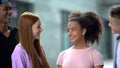 Group of teenage friends smiling each other having fun outdoors, adolescence