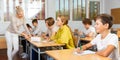 Teenage girls and boys exercising during lesson in school