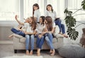 Group of teenage girls is making a selfie. Kids with phones, tablets and headphones.