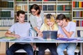 Group of teenage students studying in library class with female teacher mentor Royalty Free Stock Photo