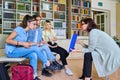 Group of teenage students studying in library class with female teacher mentor Royalty Free Stock Photo