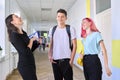 Group of teenage students talking to a female teacher in school corridor Royalty Free Stock Photo