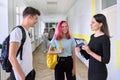 Group of teenage students talking to a female teacher in school corridor Royalty Free Stock Photo