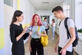 Group of teenage students talking to a female teacher in school corridor Royalty Free Stock Photo