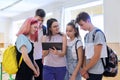 Group of teenage students and young female teacher with digital tablet in classroom Royalty Free Stock Photo