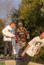 Group of teenager boys skateboarding and scooter riding in the park.