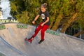 Group of teenager boys skateboarding and scooter riding in the park.