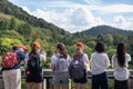 Group of teenager girls taking pictures of a Japanese pagoda with smartphones. Wearing red caps and complements, same color as the