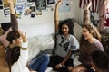 Group of teenagers in a bedroom arms raised