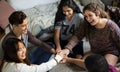 Group of teenagers in a bedroom putting their hands together community and teamwork concept