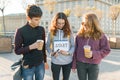 Group teenagers boy and two girls, with a notepad with handwritten word start. City background, golden hour