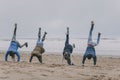 Friends Doing Handstands On A Winter Beach