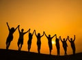 Group of Teenagers Holding Hands and Celebrate in Back Lit Royalty Free Stock Photo