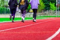 Group of teenagers running on treadmill at the stadium or arena.Young fit boys and girls in sportswear training outdoors.Concept Royalty Free Stock Photo