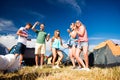 Group of teenagers at summer music festival dancing, tents Royalty Free Stock Photo