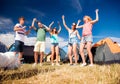 Group of teenagers at summer music festival dancing, tents Royalty Free Stock Photo