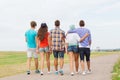 Group of teenagers walking outdoors from back