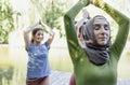 Group of teenages is engaged in fitness on pier by the lake or river. Young and positive girls go in for sports