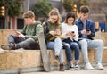 Group of teens using smartphones outdoors